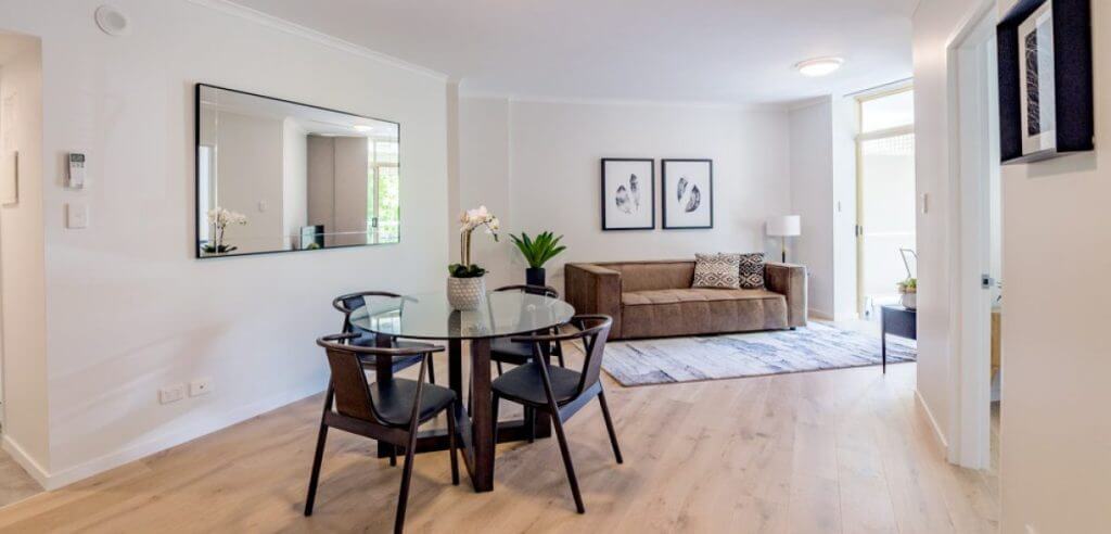 Interior design gold coast open living area with a brown coach and brown dining table